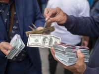 Iranian street money changers hold USD banknotes while standing on a sidewalk in the historical city of Tabriz, located 624 km (388 miles) n...