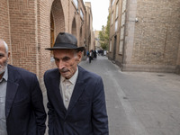 Two elderly Iranian men walk along an old street near a bazaar in the historical city of Tabriz, located 624 km northwest of Tehran in the E...