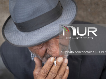 An elderly Iranian man smokes a cigarette while sitting on a sidewalk in the historical city of Tabriz, located 624 km (388 miles) northwest...