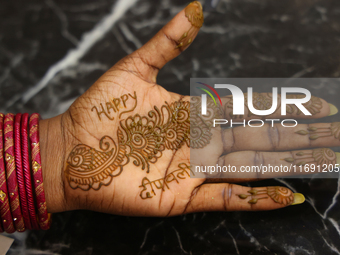 A woman displays the mehndi (henna) design applied to her hand during the Diwali and Karwa Chauth Bazaar in Mississauga, Ontario, Canada, on...