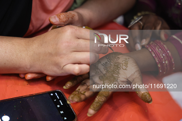 A woman has a mehndi (henna) design applied to her hand during the Diwali and Karwa Chauth Bazaar in Mississauga, Ontario, Canada, on Octobe...