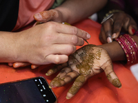 A woman has a mehndi (henna) design applied to her hand during the Diwali and Karwa Chauth Bazaar in Mississauga, Ontario, Canada, on Octobe...