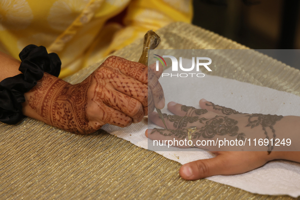 A woman has a mehndi (henna) design applied to her hand during the Diwali and Karwa Chauth Bazaar in Mississauga, Ontario, Canada, on Octobe...