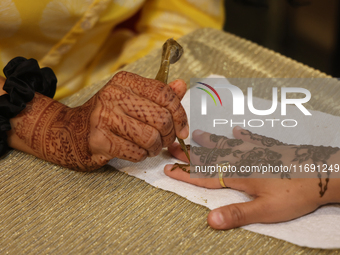 A woman has a mehndi (henna) design applied to her hand during the Diwali and Karwa Chauth Bazaar in Mississauga, Ontario, Canada, on Octobe...