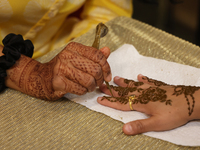 A woman has a mehndi (henna) design applied to her hand during the Diwali and Karwa Chauth Bazaar in Mississauga, Ontario, Canada, on Octobe...