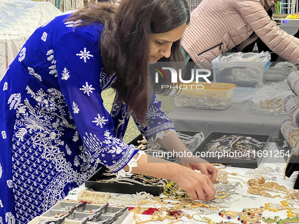 Women display traditional jewelry for customers during the Diwali and Karwa Chauth Bazaar in Mississauga, Ontario, Canada, on October 20, 20...