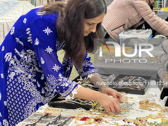 Women display traditional jewelry for customers during the Diwali and Karwa Chauth Bazaar in Mississauga, Ontario, Canada, on October 20, 20...