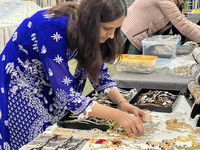 Women display traditional jewelry for customers during the Diwali and Karwa Chauth Bazaar in Mississauga, Ontario, Canada, on October 20, 20...