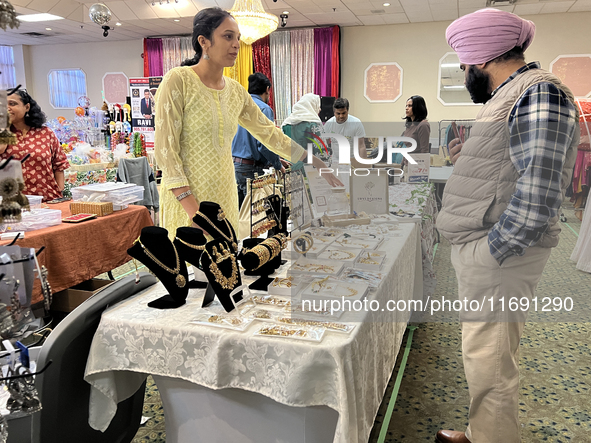 Women display traditional jewelry for customers during the Diwali and Karwa Chauth Bazaar in Mississauga, Ontario, Canada, on October 20, 20...