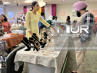 Women display traditional jewelry for customers during the Diwali and Karwa Chauth Bazaar in Mississauga, Ontario, Canada, on October 20, 20...