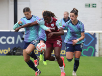 In Dagenham, England, on October 20, 2024, Kyra Cooney-Cross of Arsenal Women, Viviane Asseyi of West Ham United, and Emily Fox of Arsenal c...