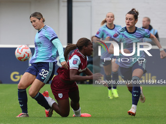 In Dagenham, England, on October 20, 2024, Kyra Cooney-Cross of Arsenal Women, Viviane Asseyi of West Ham United, and Emily Fox of Arsenal c...