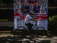 Several motorists pass by a banner expressing congratulations to the elected presidential pair for the 2024-2029 period, Prabowo Subianto-Gi...