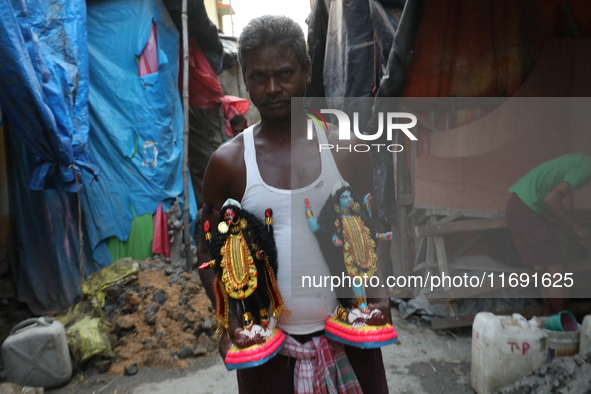 An artist carries idols of the Hindu goddess Kali inside a workshop in Kolkata, India, on October 21, 2024. Diwali comes from the Sanskrit w...