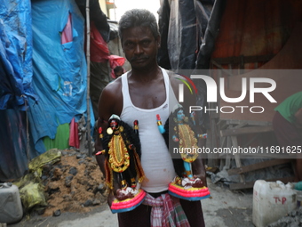 An artist carries idols of the Hindu goddess Kali inside a workshop in Kolkata, India, on October 21, 2024. Diwali comes from the Sanskrit w...