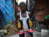 An artist carries idols of the Hindu goddess Kali inside a workshop in Kolkata, India, on October 21, 2024. Diwali comes from the Sanskrit w...