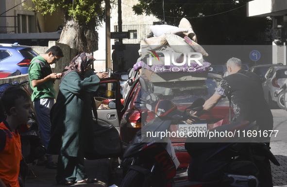 Displaced people who flee Israeli bombardment in Beirut's southern suburbs clash with Lebanese security forces attempting to evict them from...