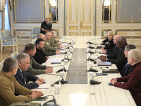 US Secretary of Defense Lloyd Austin and President of Ukraine Volodymyr Zelenskyy sit at the table across from each other during the meeting...