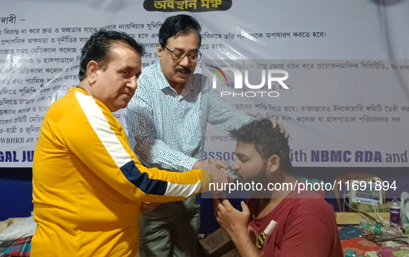 Dr. Sandip Mandal, a second-year PGT in the Orthopaedic department, drinks water to break his hunger strike protest on the eighth day of his...