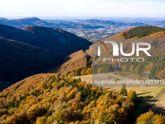 Aerial View of Moravian-Silesian Beskids mountain range as autumn trees shine with colours in Czech Republic on October 20, 2024. The range...