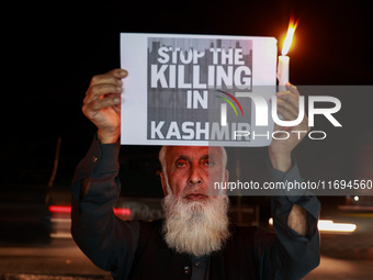 Religious leaders, young boys, and political leaders hold placards and Indian national flags as they protest against the killings of Gagange...