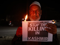 Religious leaders, young boys, and political leaders hold placards and Indian national flags as they protest against the killings of Gagange...