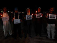 Religious leaders, young boys, and political leaders hold placards and Indian national flags as they protest against the killings of Gagange...