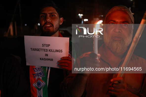 Religious leaders, young boys, and political leaders hold placards and Indian national flags as they protest against the killings of Gagange...