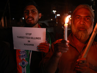 Religious leaders, young boys, and political leaders hold placards and Indian national flags as they protest against the killings of Gagange...