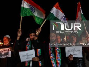 Religious leaders, young boys, and political leaders hold placards and Indian national flags as they protest against the killings of Gagange...