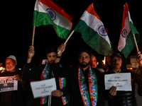 Religious leaders, young boys, and political leaders hold placards and Indian national flags as they protest against the killings of Gagange...