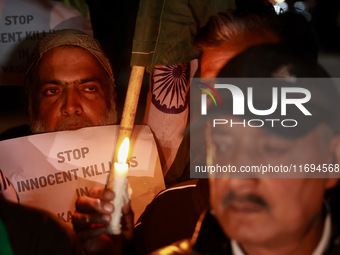 Religious leaders, young boys, and political leaders hold placards and Indian national flags as they protest against the killings of Gagange...