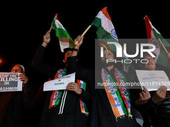 Religious leaders, young boys, and political leaders hold placards and Indian national flags as they protest against the killings of Gagange...