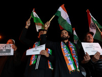 Religious leaders, young boys, and political leaders hold placards and Indian national flags as they protest against the killings of Gagange...