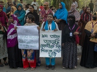 Protesters from the Domestic Workers' National Forum form a human chain at the Shaheed Minar in Dhaka, Bangladesh, on October 22, 2024, dema...