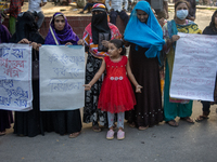 Protesters from the Domestic Workers' National Forum form a human chain at the Shaheed Minar in Dhaka, Bangladesh, on October 22, 2024, dema...