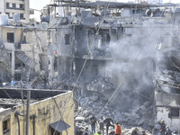 Civilians, paramedics, and Civil Defense Search and Rescue teams conduct search and rescue operations among the rubble of collapsed building...