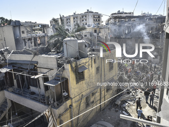 Civilians, paramedics, and Civil Defense Search and Rescue teams conduct search and rescue operations among the rubble of collapsed building...