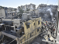 Civilians, paramedics, and Civil Defense Search and Rescue teams conduct search and rescue operations among the rubble of collapsed building...