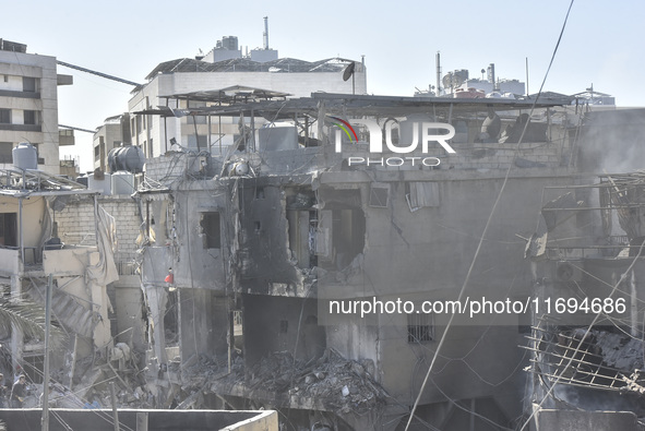 Civilians, paramedics, and Civil Defense Search and Rescue teams conduct search and rescue operations among the rubble of collapsed building...