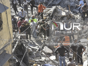 Civilians, paramedics, and Civil Defense Search and Rescue teams conduct search and rescue operations among the rubble of collapsed building...