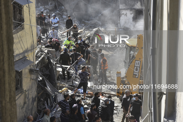 Civilians, paramedics, and Civil Defense Search and Rescue teams conduct search and rescue operations among the rubble of collapsed building...