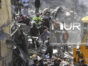 Civilians, paramedics, and Civil Defense Search and Rescue teams conduct search and rescue operations among the rubble of collapsed building...