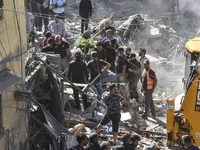 Civilians, paramedics, and Civil Defense Search and Rescue teams conduct search and rescue operations among the rubble of collapsed building...