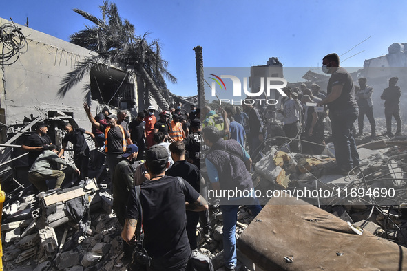 Civilians, paramedics, and Civil Defense Search and Rescue teams conduct search and rescue operations among the rubble of collapsed building...