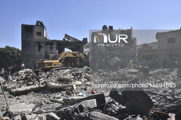 Civilians, paramedics, and Civil Defense Search and Rescue teams conduct search and rescue operations among the rubble of collapsed building...