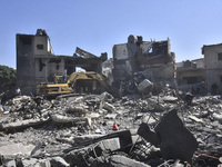 Civilians, paramedics, and Civil Defense Search and Rescue teams conduct search and rescue operations among the rubble of collapsed building...