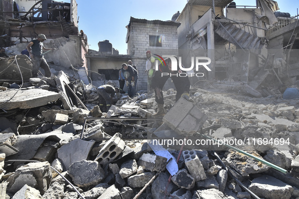 Civilians, paramedics, and Civil Defense Search and Rescue teams conduct search and rescue operations among the rubble of collapsed building...