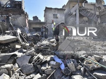 Civilians, paramedics, and Civil Defense Search and Rescue teams conduct search and rescue operations among the rubble of collapsed building...