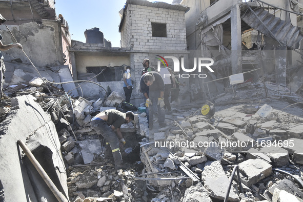 Civilians, paramedics, and Civil Defense Search and Rescue teams conduct search and rescue operations among the rubble of collapsed building...